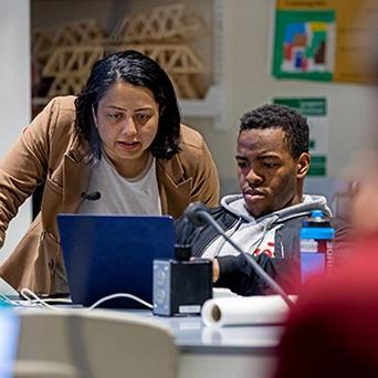 Student and professor looking at computer